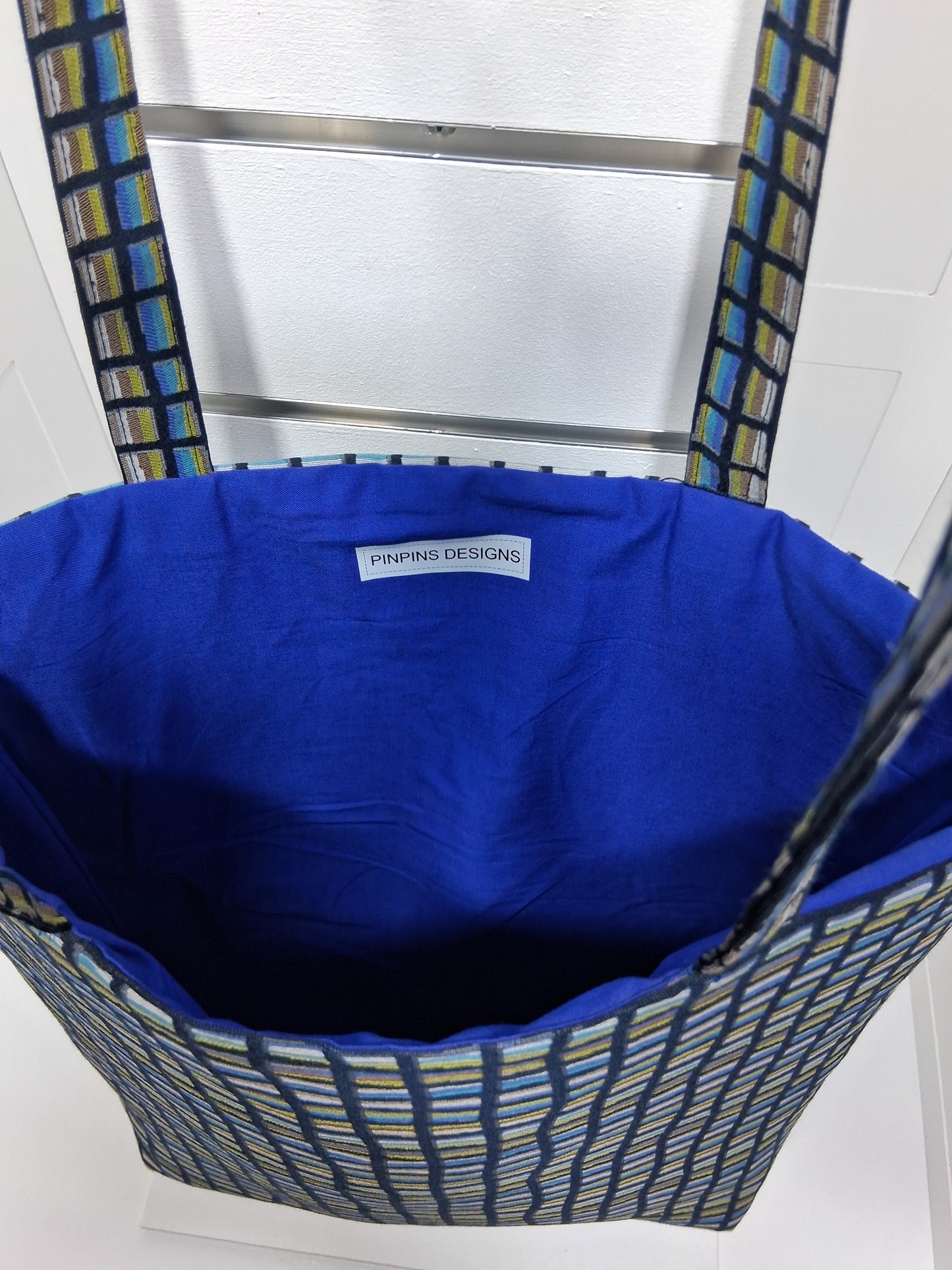 Pinpins Designs handmade tote bag- interior view showing royal blue lining and Pinpins Designs brand label.