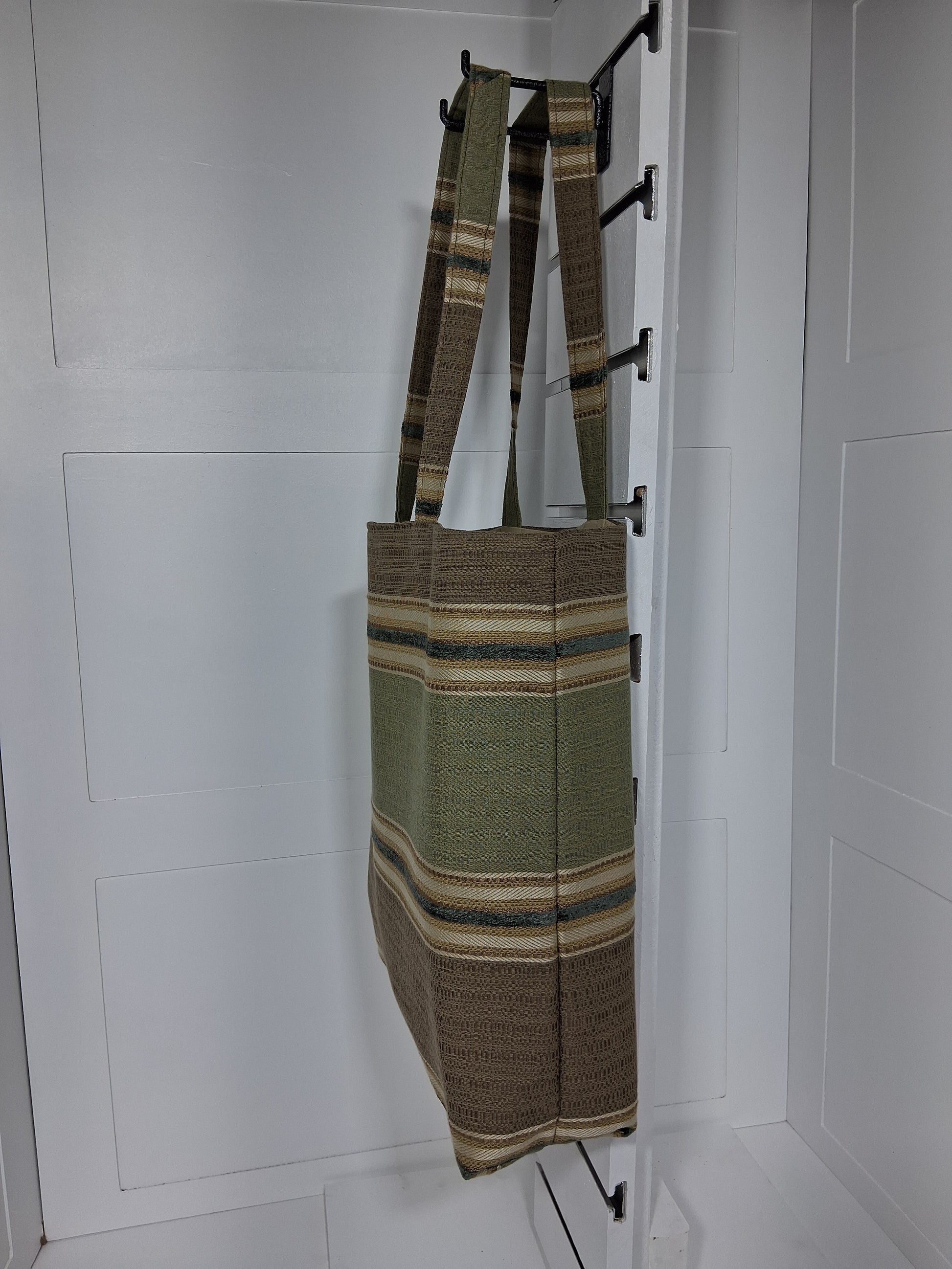 Side: "Side view of Pinpins Designs olive striped woven tote bag showing depth and long shoulder handles"