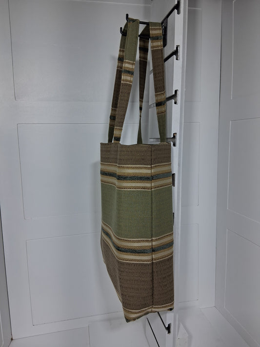 Side: "Side view of Pinpins Designs olive striped woven tote bag showing depth and long shoulder handles"