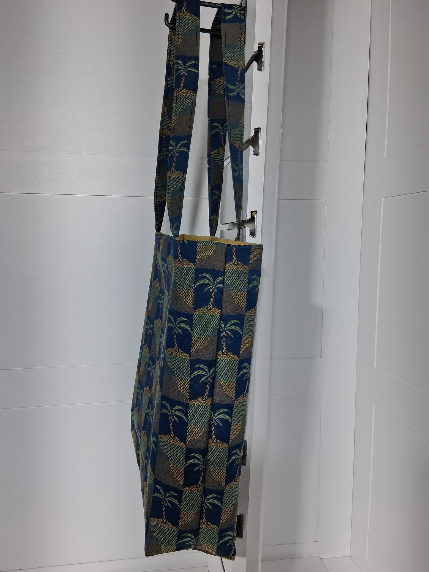 Side: "Side view of Pinpins Designs palm tree tapestry tote bag showing depth and long shoulder handles"