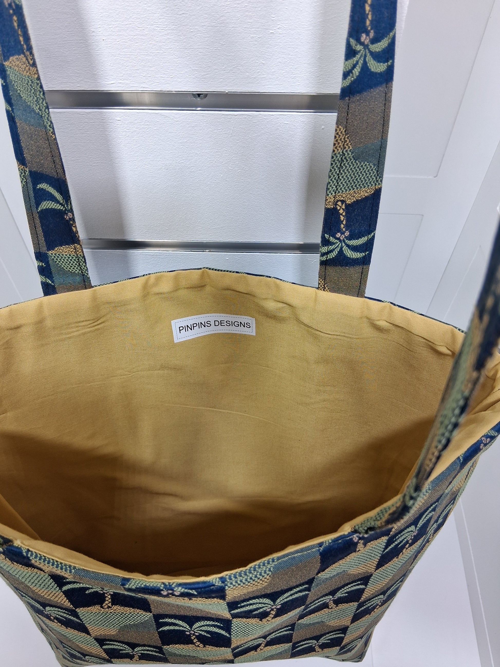 Interior: "Interior view of Pinpins Designs tote bag showing spacious golden yellow lining and handmade Pinpins Designs label"