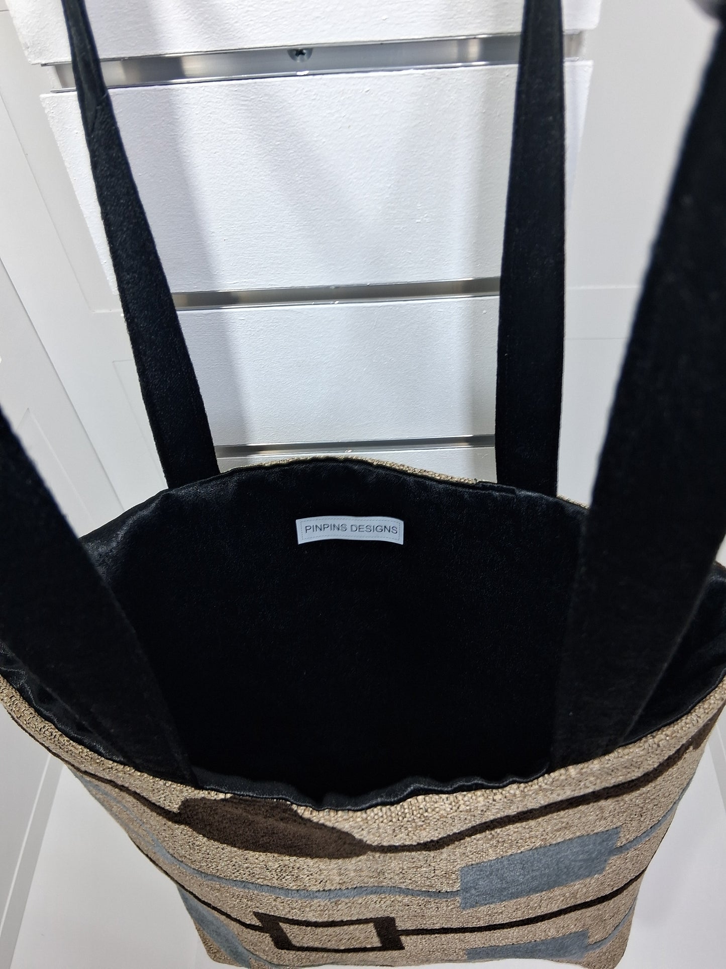 "Pinpins Designs handmade tote bag – interior view showing black lining and Pinpins Designs brand label"