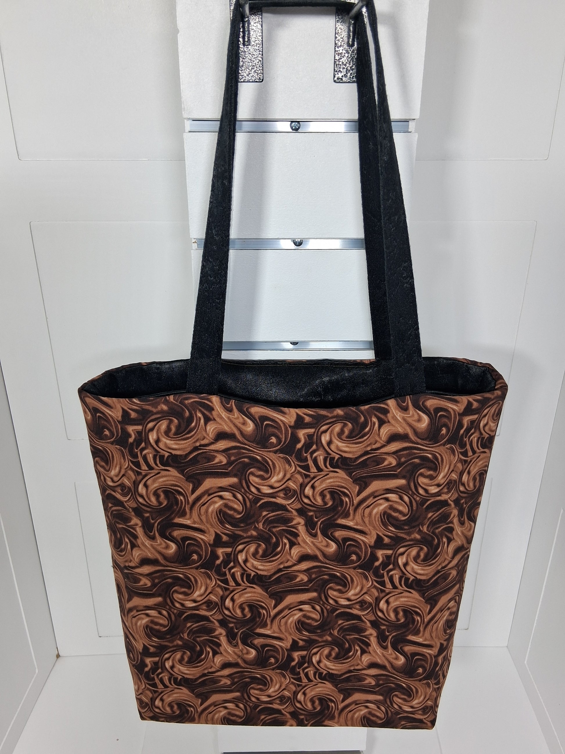 "Pinpins Designs handmade tote bag – front view, chocolate brown and copper swirl fabric with black handles"